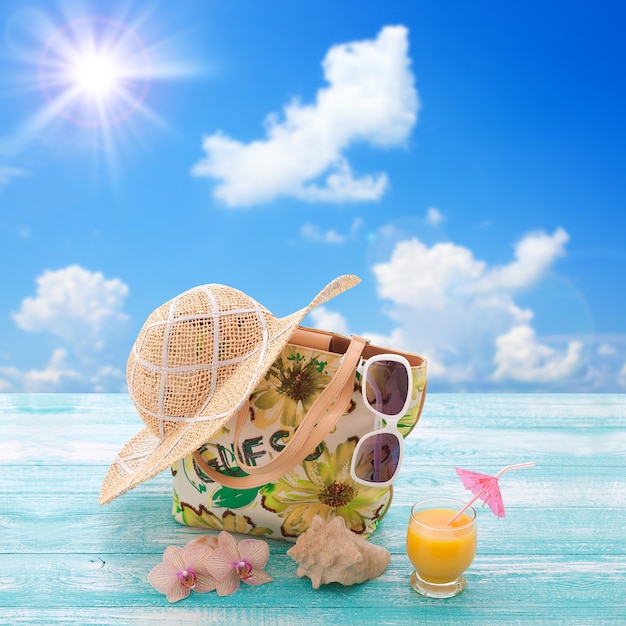 Óculos de sol de roupas da moda, chapéu, chinelos para férias na praia. suco de laranja. mock up plana para design. vista do topo. conceito de férias de verão.