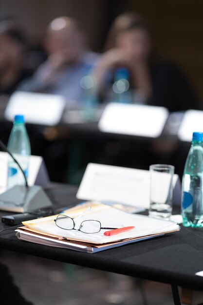 Foto Óculos e caneta sobre o arquivo na mesa no seminário