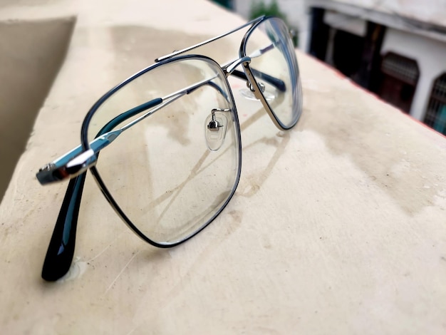 Foto Óculos elegantes com armação de metal na parede da varanda óculos que corrigem a visão de turva a nítida