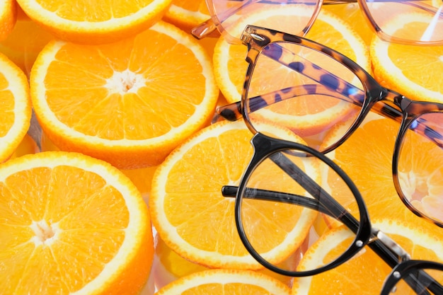 Óculos em fatias de laranja, vários pares de óculos em fatias redondas de espaço de cópia de laranja