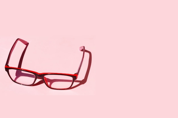 Foto Óculos em fundo rosa com sombras