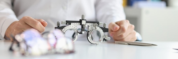 Óculos para verificar a visão deitado na mesa perto do médico oftalmologista closeup