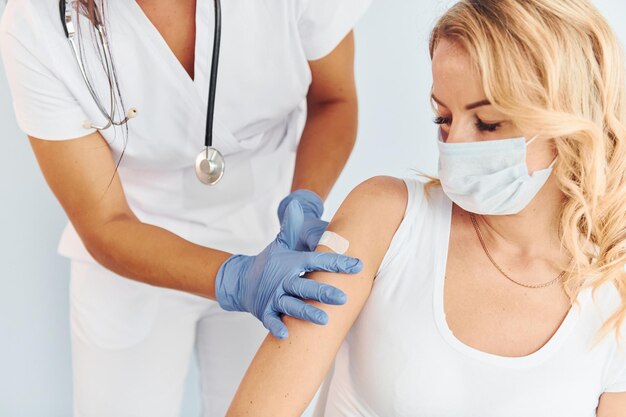 Ocupação profissional Médico de uniforme fazendo vacinação ao paciente