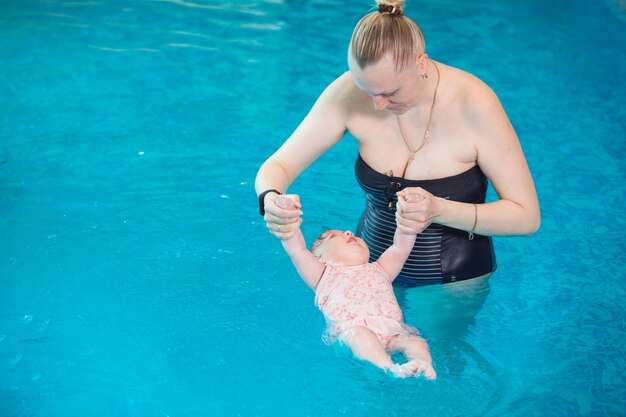 Ocupación en la piscina de niños con un entrenador de natación.