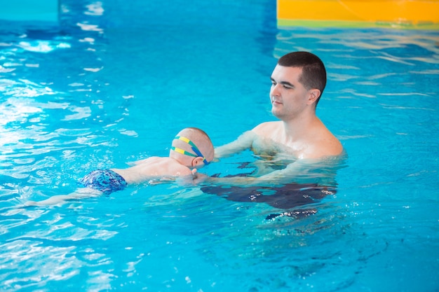 Ocupación en la piscina de niños con un entrenador de natación.