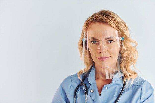 Ocupación profesional Joven doctora en uniforme está en el interior