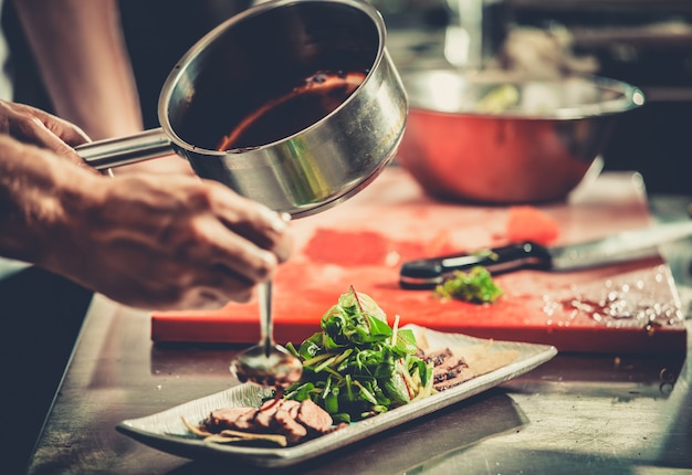 Ocupado chef en el trabajo en la cocina del restaurante