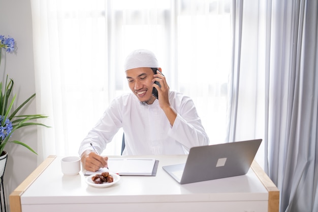 Ocupado empresario musulmán asiático hacer una llamada telefónica con su teléfono móvil