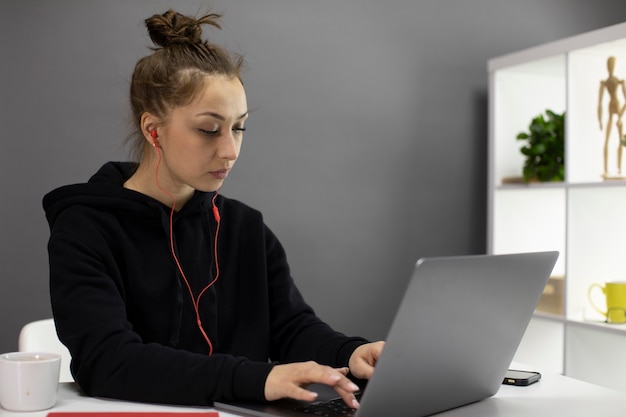 Ocupado encantador freelancer feminino em roupas casuais, trabalhando no projeto em casa