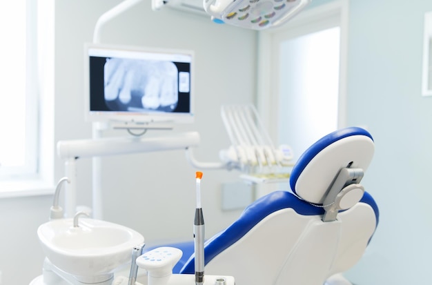 odontologia, medicina, equipamentos médicos e conceito de estomatologia - interior do novo escritório moderno de clínica odontológica com cadeira