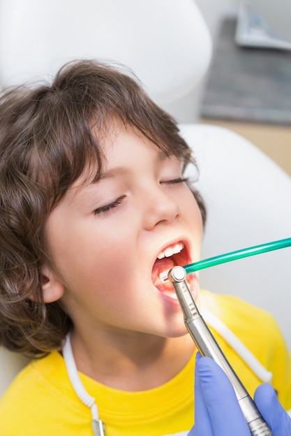 Foto odontologia pediátrica examinando dentes de meninos na cadeira de dentistas