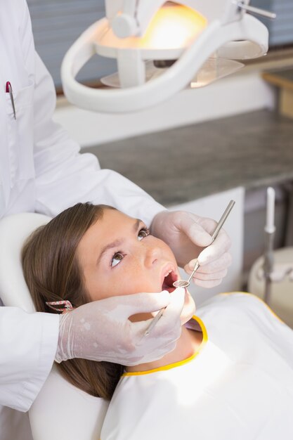 Odontologia pediátrica examinando dentes de pacientes na cadeira de dentistas