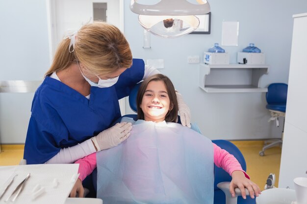 Odontopediatra examinando o paciente sorridente dele