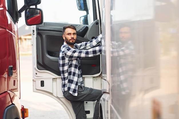 Foto Öffnen der tür junger lkw-fahrer ist tagsüber bei seinem fahrzeug