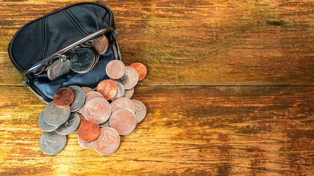 Foto Öffnen sie die schwarze brieftasche aus leder mit verschiedenen münzen. finanzkrise, armut, geldmangel.