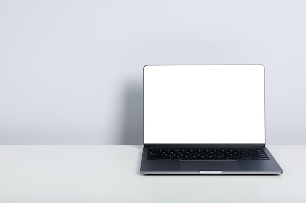Öffnen Sie einen Laptop mit leerem Bildschirm auf einem weißen Tisch