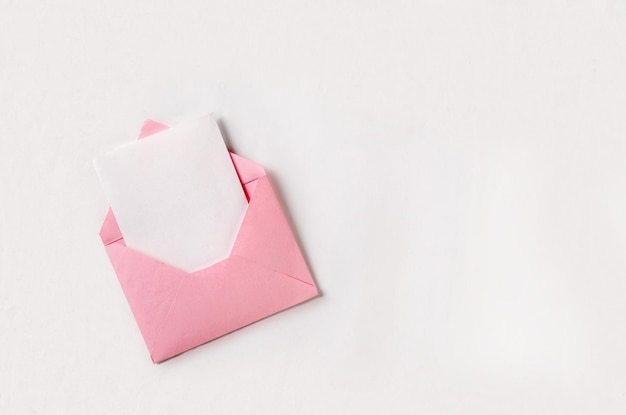 Öffnen Sie rosa Umschlag mit Papierblatt