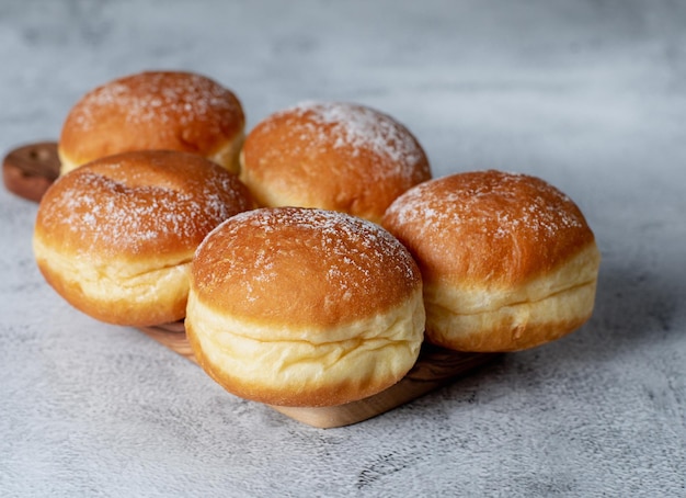 Foto Österreichische und deutsche donuts oder krapfen faschingskrapfen berliner mit sahne auf grauem hintergrund