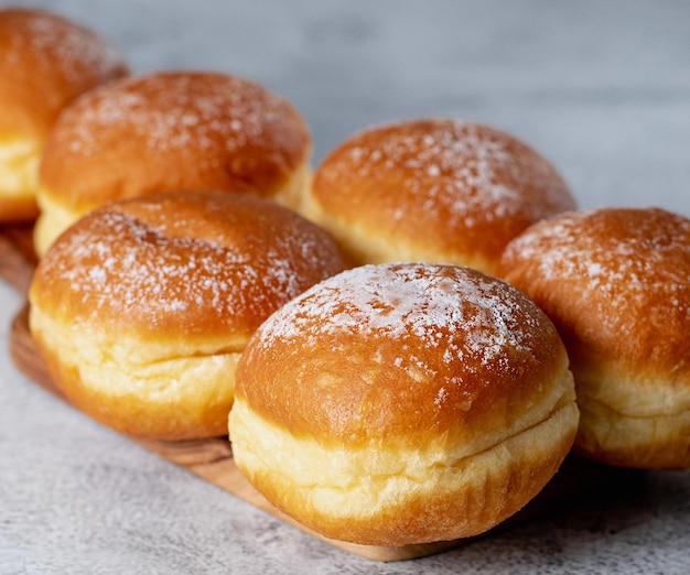 Österreichische und deutsche donuts oder krapfen faschingskrapfen berliner mit sahne auf grauem hintergrund