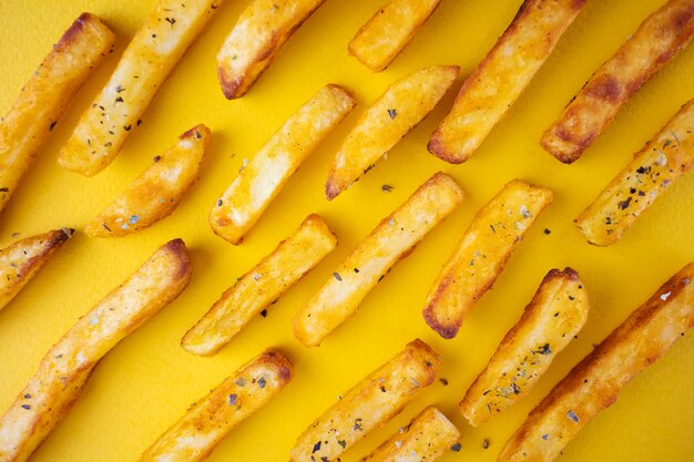 Ofenkartoffeln mit aromatischen Kräutern auf einem gelben Hintergrund.