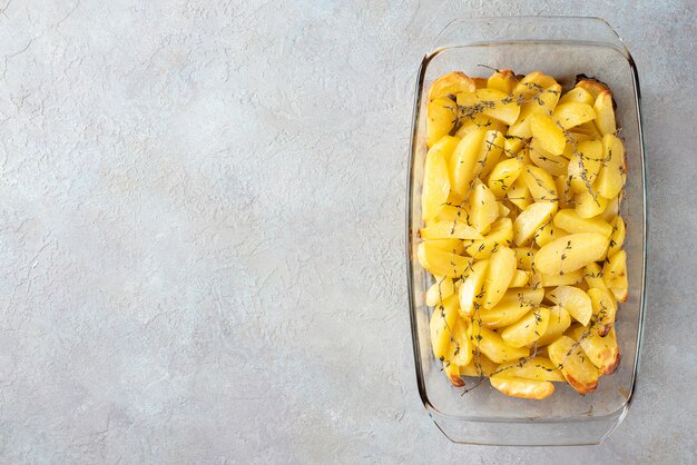 Ofenkartoffeln mit Olivenöl, Knoblauch und Thymian in Glasform. Flachgelegt, Draufsicht.