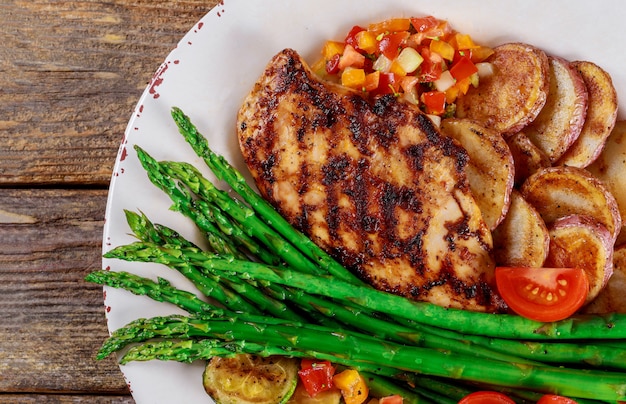 Ofenkartoffeln und Spargel auf einer weißen Platte mit Tomate