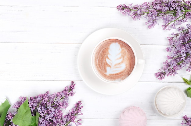 Сoffee con arte latte y malvavisco en mesa de madera blanca