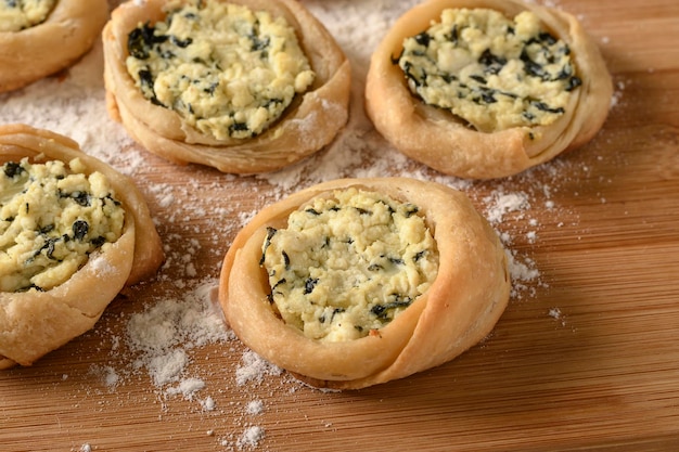 Offener Sfiha gefüllt mit Ricotta und Spinat auf einem Holz