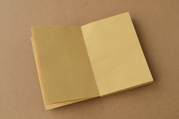 Offenes Buch. Notizbuch auf braunem Kraftpapier, offene leere Seiten Notizblock-Draufsicht, Mock-up, Kopierraum
