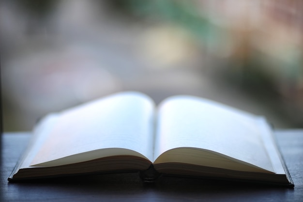 offenes Buch und ein Tisch vor dem Fenster