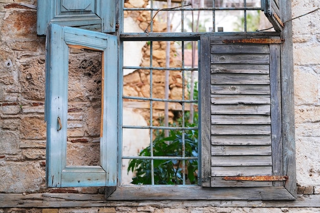 Offenes Fenster in einem verlassenen Haus aus Stein- und Zementpflanzen wachsen im Inneren