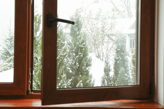 Offenes Fenster mit Blick auf verschneite Tage
