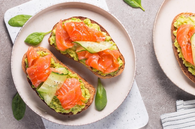 Offenes Sandwich mit geräuchertem und gesalzenem Lachs für ein gesundes Frühstück. Forelle und Avocado auf Bruschetta t