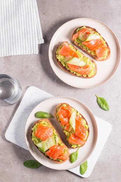 Offenes Sandwich mit geräuchertem und gesalzenem Lachs für ein gesundes Frühstück. Forelle und Avocado auf Bruschetta t