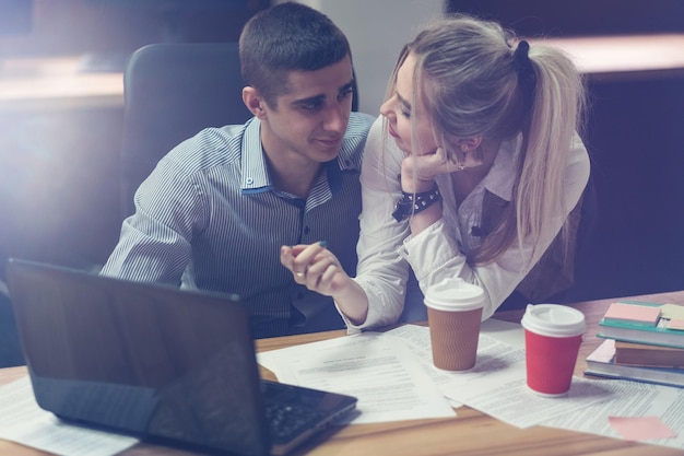 Office flirt atracción mutua química colegas discutiendo el trabajo sonriendo espacio de trabajo contemporáneo