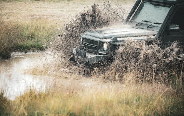 Offroad-Auto auf Bergstraße Offroad-Fahrt auf Bergstraße Schlamm und Wasserspritzer bei Offroad-Rennen