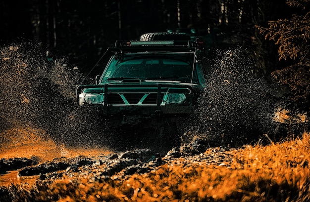 Offroad-Sportwagen zwischen Bergen Landschaft Expedition Offroad Offroad-Fahrzeug fährt auf Bergweg Beste Off Road-Fahrzeuge Schlamm und Wasser Spritzen im Offroad-Rennen
