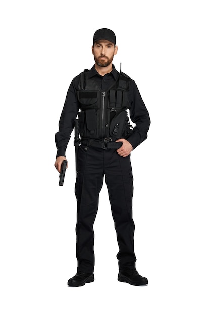 Oficial de policía confiado en uniforme negro posando con arma en el interior vista frontal del policía barbudo