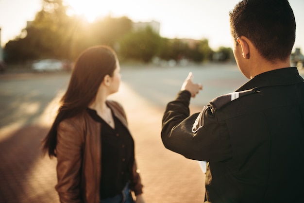 El oficial de policía muestra el lugar de estacionamiento al conductor