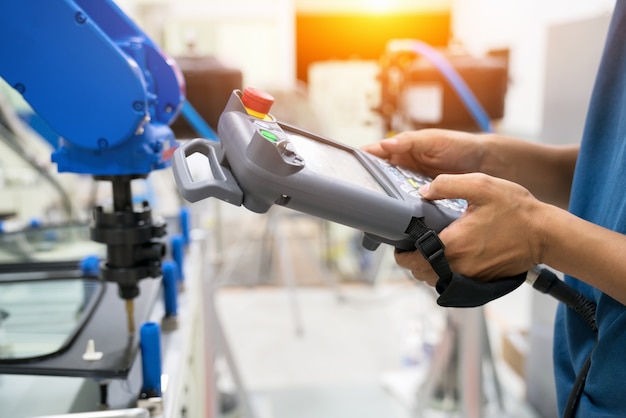 El oficial profesional le enseña el robot usando el panel de control al cristal en la base de la plantilla