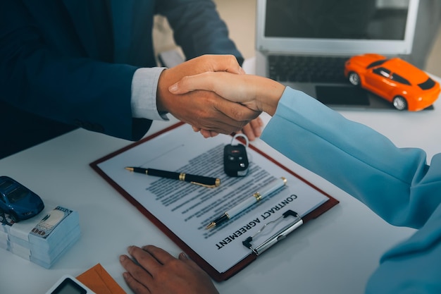 Foto los oficiales de seguros entregan las llaves del coche después de que el inquilino haya firmado un documento de seguro de automóvil o un documento de arrendamiento o acuerdo comprar o vender un coche nuevo o usado con un coche