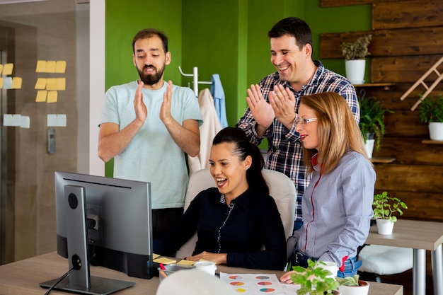 En la oficina creativa de la empresa, los empleados están celebrando un gran logro.