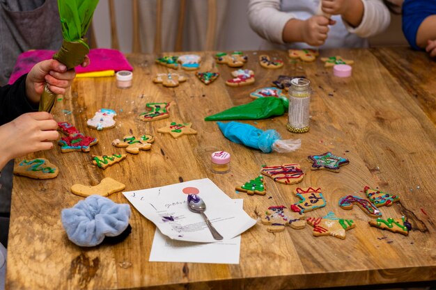 Oficina de biscoitos de Natal Crianças decorando biscoitos com sacos de confeitar coloridos