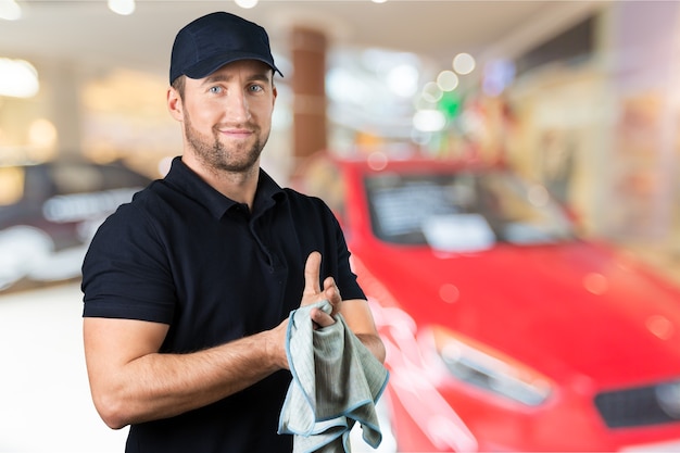 Oficina de conserto de automóveis, mecânico masculino perto do carro