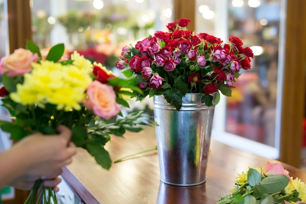 Oficina de floricultura, confecção de buquês e arranjos de flores. mulher coletando um buquê de flores