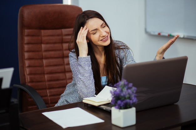 La oficina es un apuesto hombre de negocios que trabaja en una computadora personal en su escritorio.