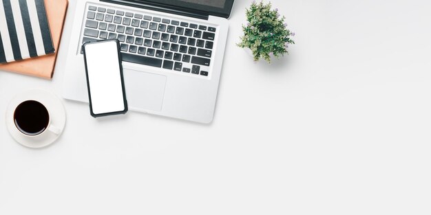 Oficina de escritorio con computadora portátil Pantalla en blanco teléfono inteligente taza de café Notebook en fondo blanco Vista superior con espacio de copia Mock upx9