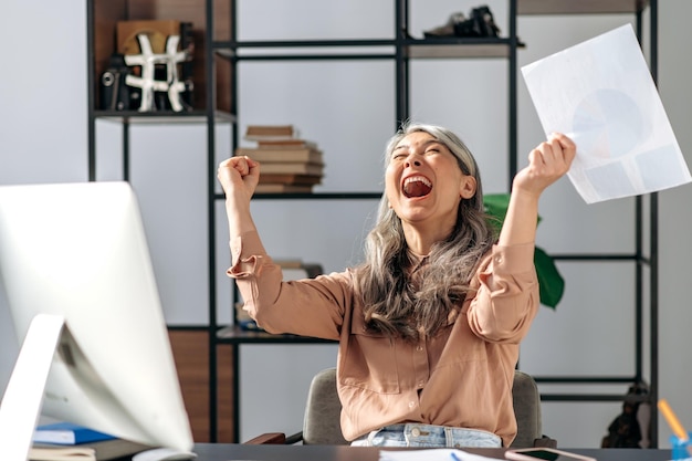 Oficina de líder de negocios de mujer asiática madura feliz gesticulando sonriendo