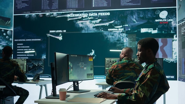 Oficina militar de alta tecnología con soldados analizando datos en tiempo real