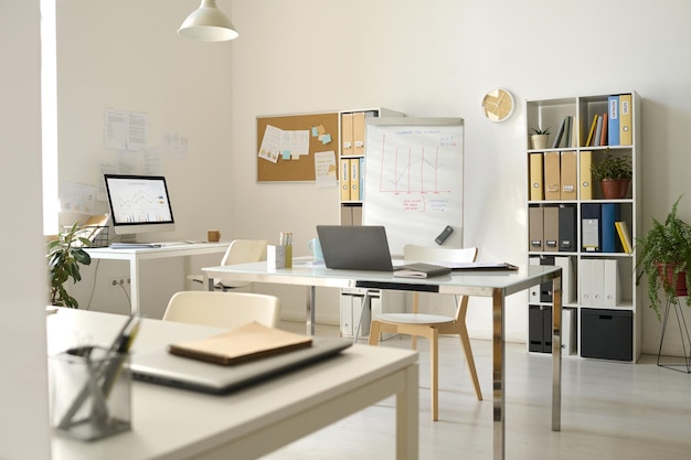 Oficina moderna con lugares de trabajo con computadoras y flipchart para presentaciones